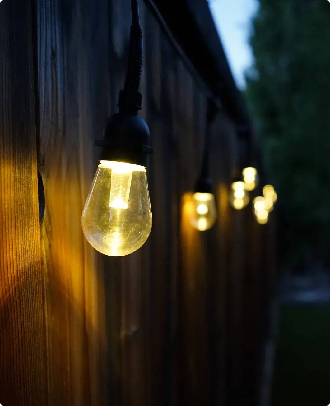 Backyard with a gazebo and patio string lights at dusk