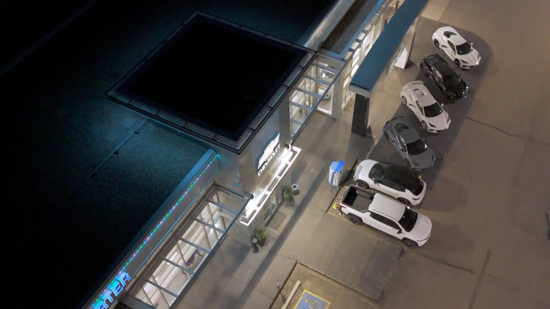 Aerial view of a car dealership with Gemstone lights along every roofline at night