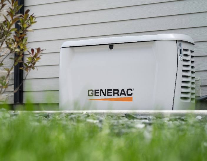 Generac standby generator on a pad beside a house