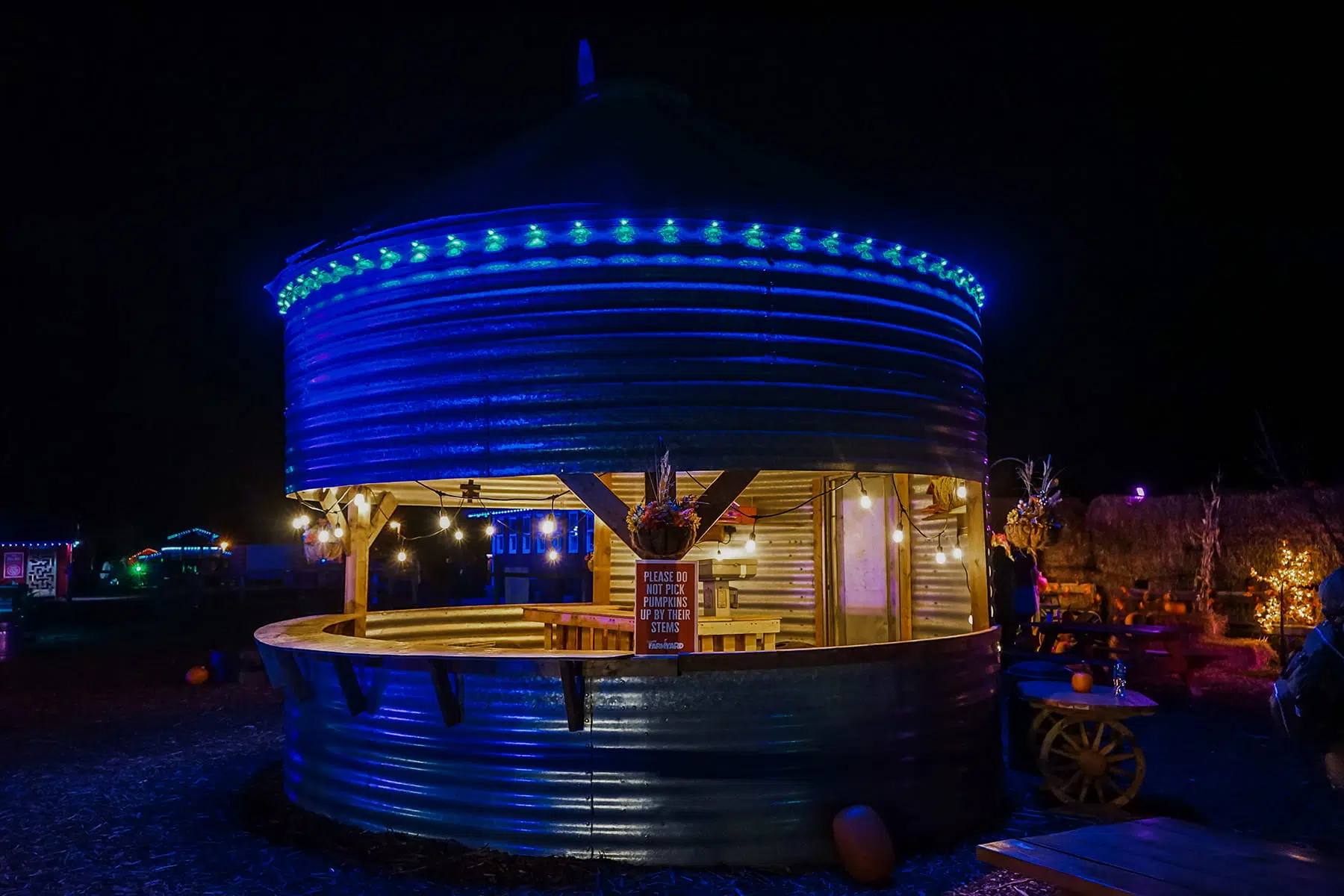 Grain bin turned into a kiosk, lit blue with Gemstone lights