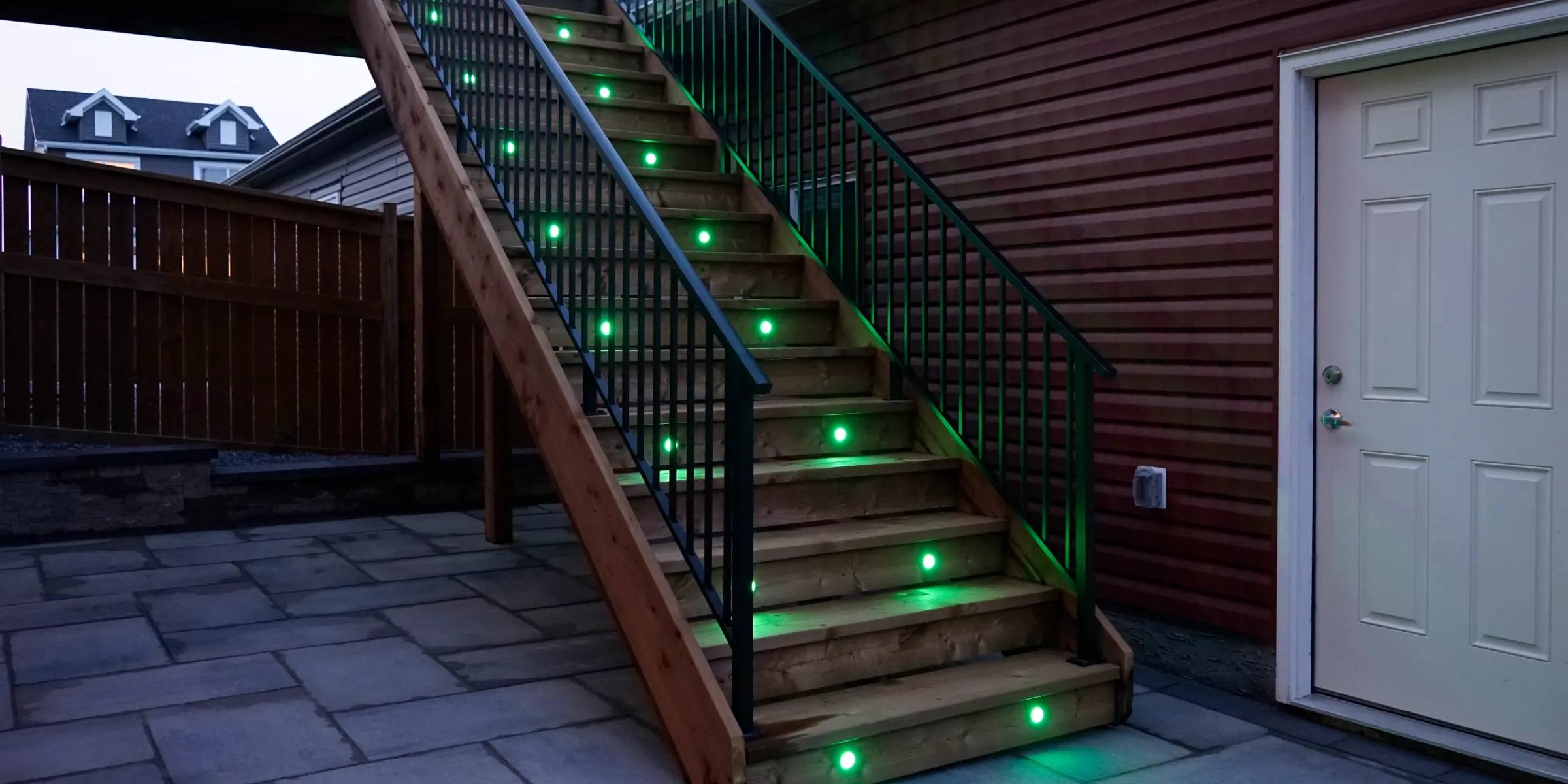 Outdoor wooden stairs with green Gemstone deck lights in each tread