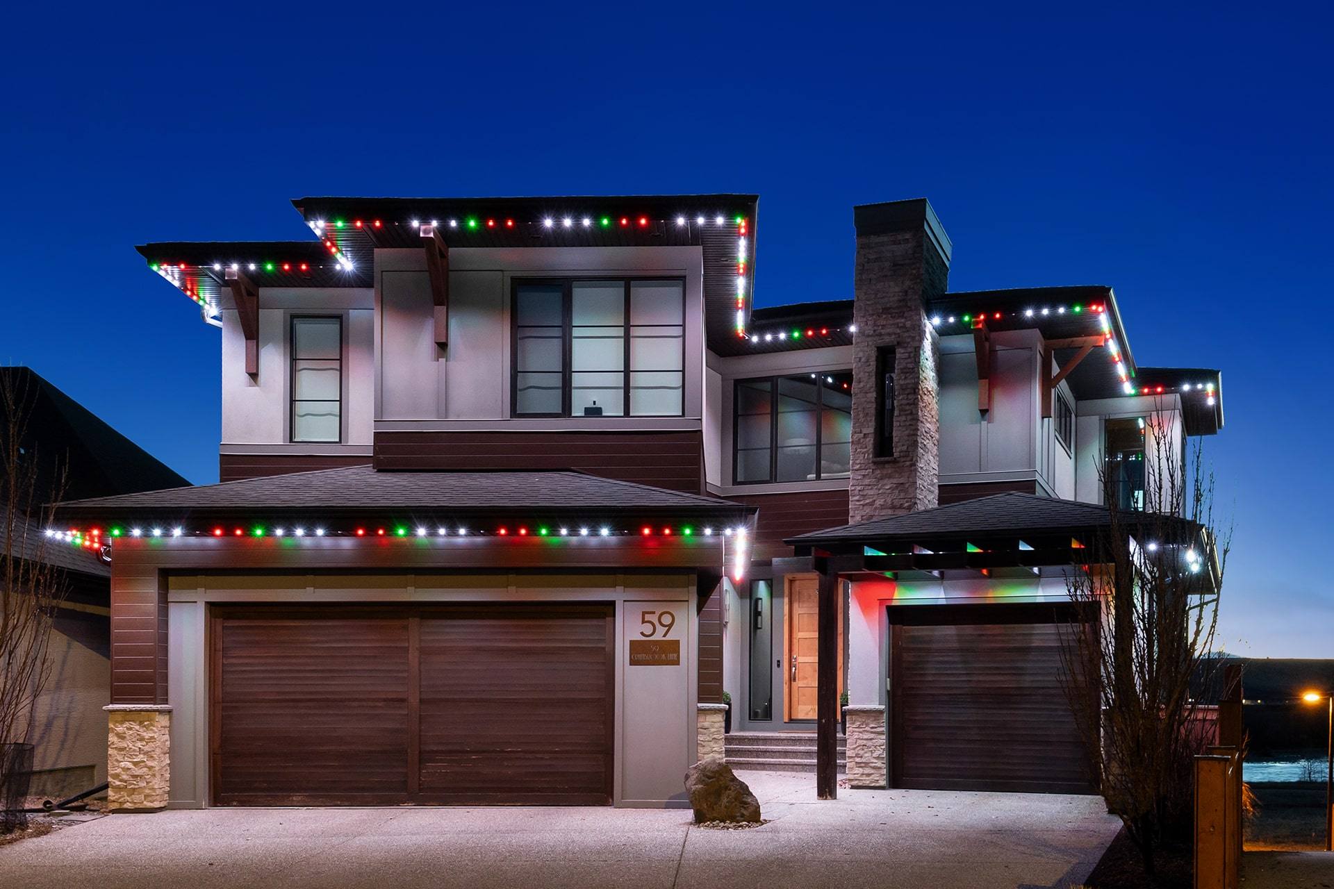 Two-storey home with red and green Gemstone Christmas lights