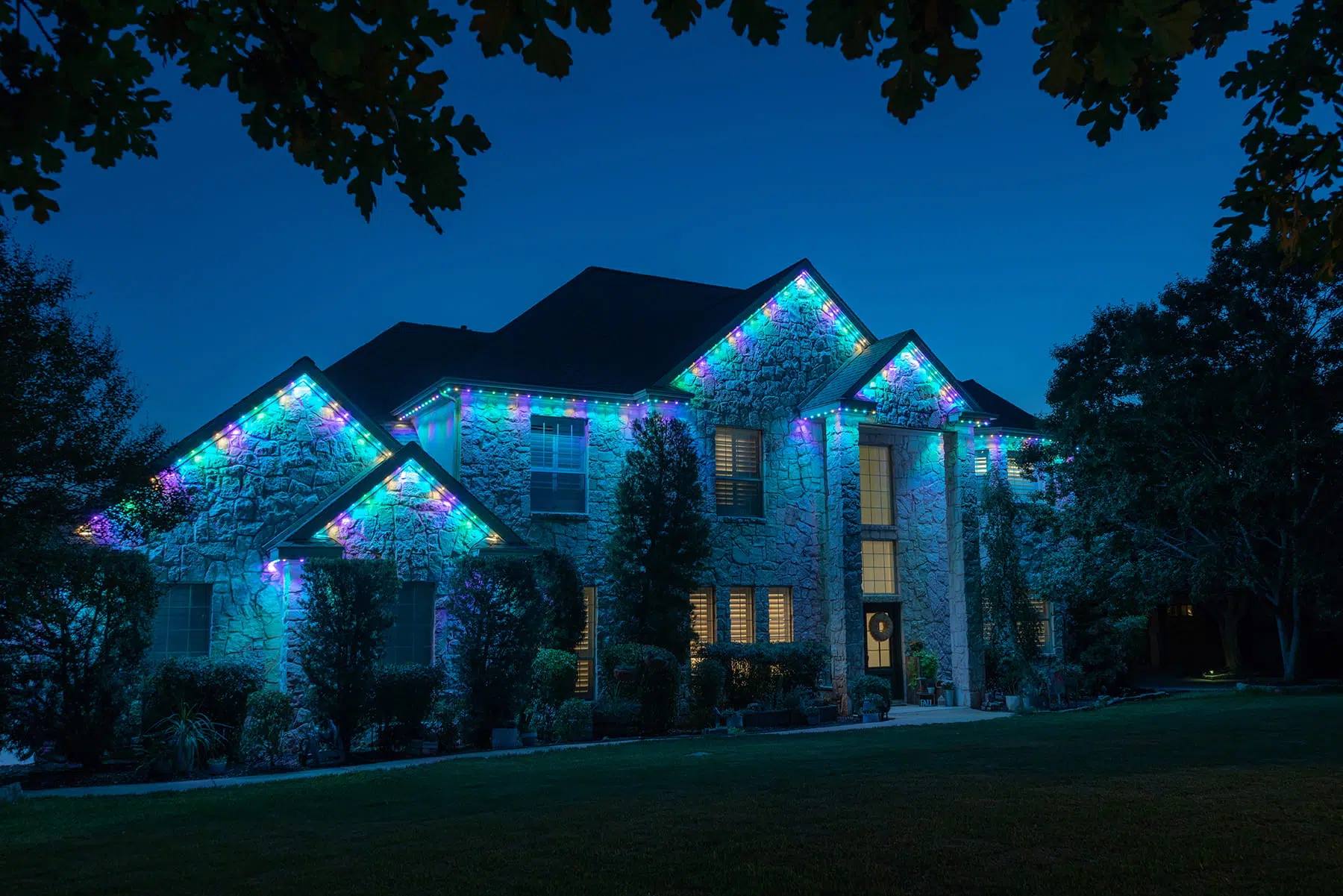 Large stone home lit teal with Gemstone lights