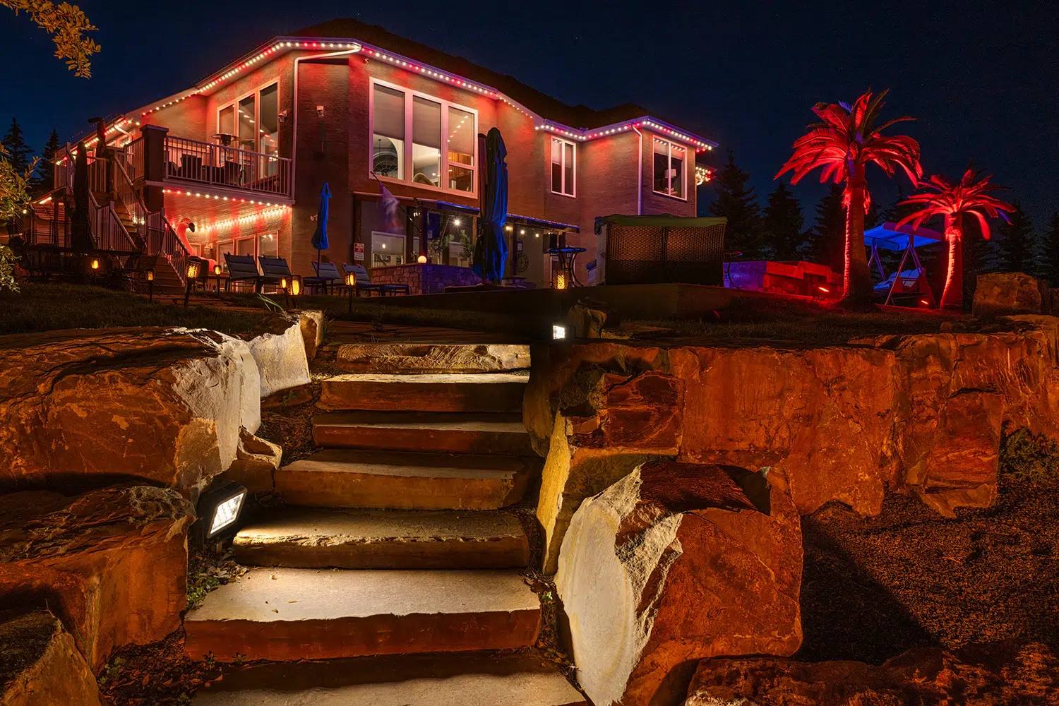 Stone steps and trees lit red with Gemstone landscape lights