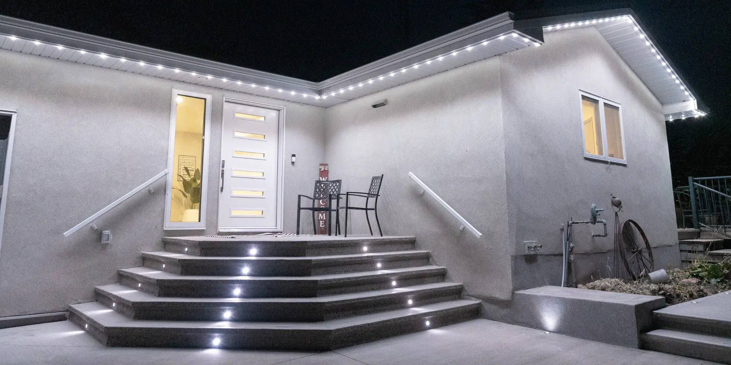 Stucco home with lit front steps and roofline